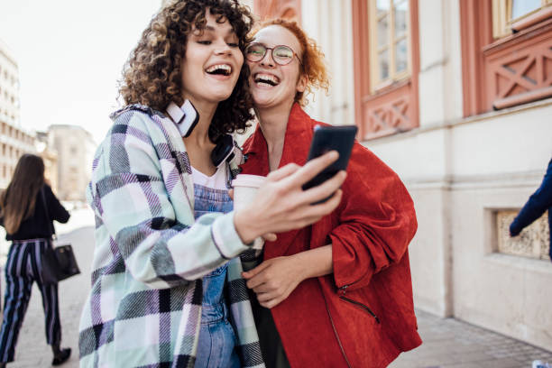 istock Two girls using smartphone on the move and having fun 1422911531