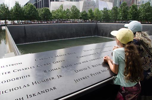 Mother and daughter at North Tower Pool of ground zero in New York City during summer day