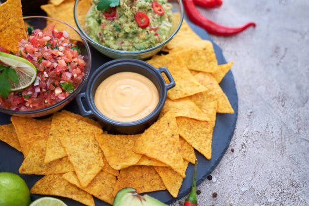 istock freshly made salsa and guacamole dip sauce with nacho chips on stone serving board 1422912328