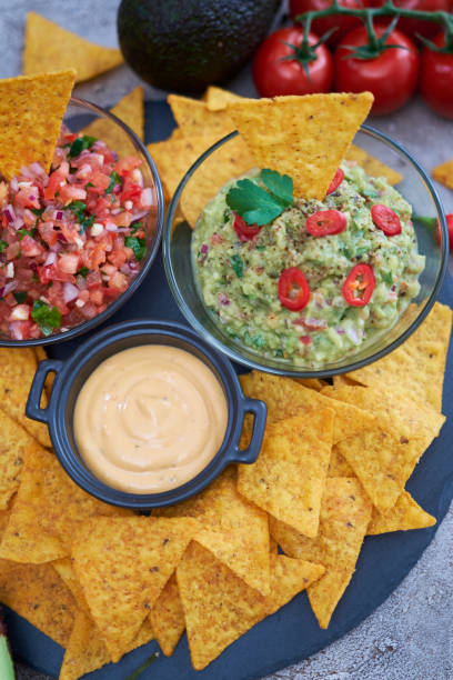 istock freshly made salsa and guacamole dip sauce with nacho chips on stone serving board 1422912330