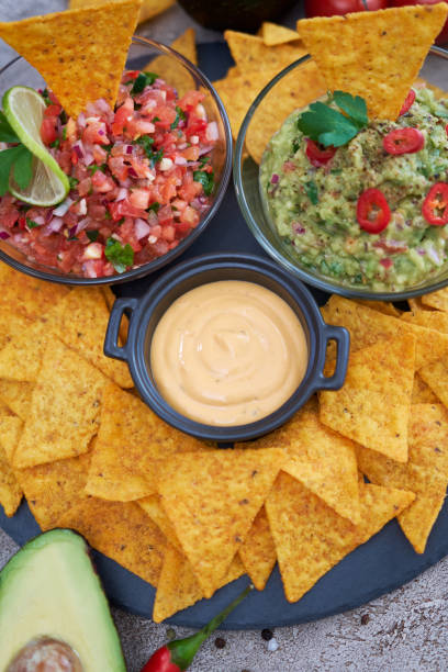 istock freshly made salsa and guacamole dip sauce with nacho chips on stone serving board 1422912332