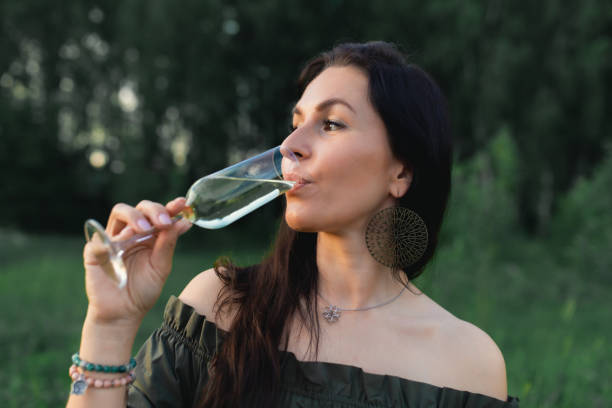 istock An attractive woman drinks champagne on a forest plot surrounded by nature. 1422912969