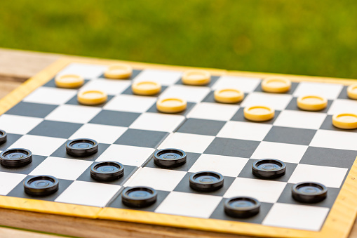 Draughts board game details being played outdoors