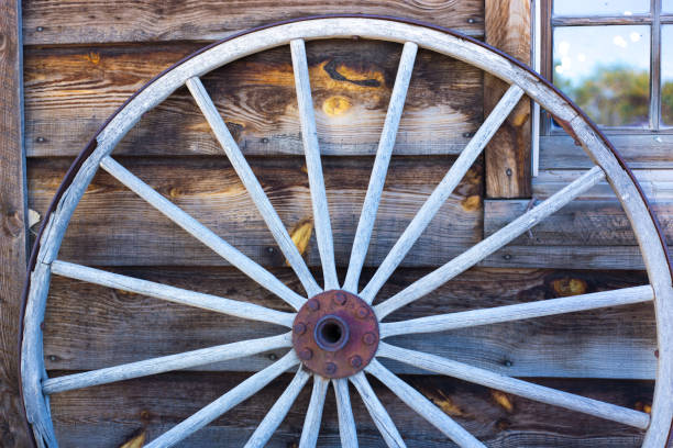 istock Taos, NM Style: Old Wood Wagon Wheel Against Wood Shingles 1422928229
