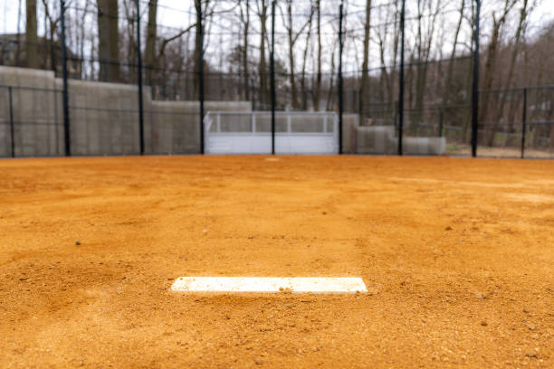 istock View of typical nondescript high school softball clay infield looking from pitching rubber toward home plate.  No people visible.  Not a ticketed event. 1422935575