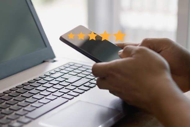 Customer service experience and business satisfaction survey concept. Close up customer hand using a smartphone to give a five-star rating. Review, feedback, Service rating, satisfaction.