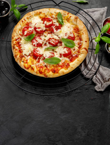 istock Freshly baked pizza on dark background. 1422948172