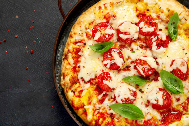 istock Freshly baked pizza on dark background. 1422948363