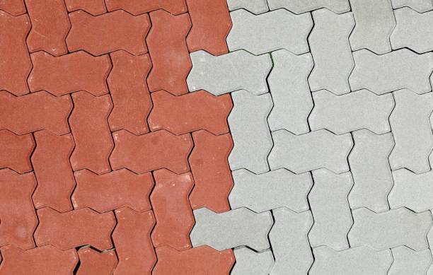 red and gray interlocking concrete paver blocks. irregular shaped tiles for outdoor pavement. samples. - interlocked imagens e fotografias de stock