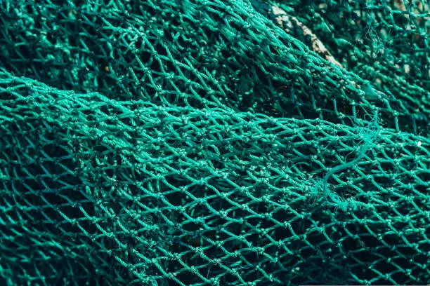 Photo of Abstract close-up macro real photo beautiful wallpaper. Fisherman rope net texture fiber surface pattern. Sea blue green light colour. Futuristic subtle waving lines art modern. Dark background