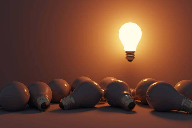 istock One glowing light bulb standing out from the unlit incandescent bulbs. 1422971812