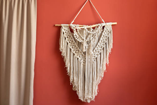 istock Wall panel in style of Boho made of cotton threads using the macrame technique for home decor and wedding decoration. 
Cozy Home decor concept. White Macrame in living room with boho interior design 1422977299