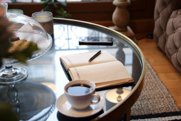Smartphone and notepad with pen placed on table in home