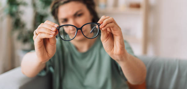 The girl looks at the glasses checking for dirt stock photo