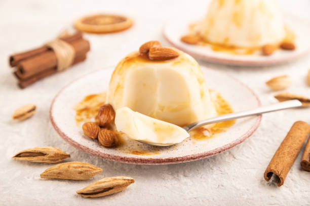 istock White milk jelly with caramel sauce on gray concrete, side view, selective focus. 1422987713
