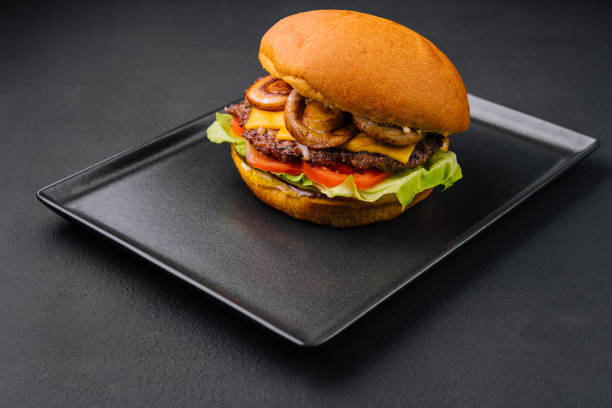 istock Burger with mushrooms and cutlet on black tray 1422991106