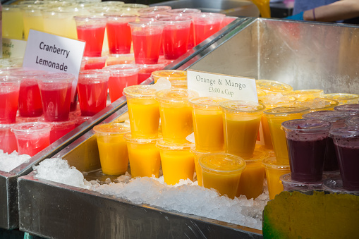 A variety of juice served in plastic cups on display at Borough Market in London, England