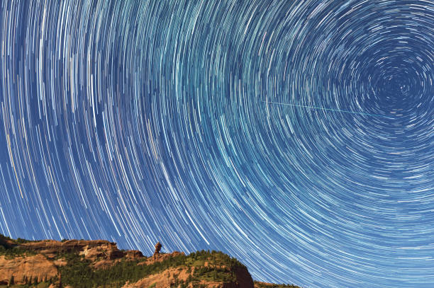 paisaje nocturno, senderos de estrellas sobre las montañas. - star trail clear sky tranquil scene circle fotografías e imágenes de stock