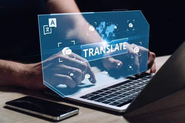 Photo of The concept of software for translation between different languages. The person works at the computer.