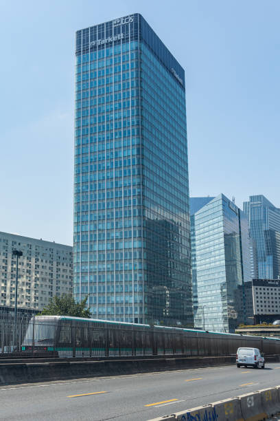 tour initiale or tour nobel, the tarkett s.a and tcs france headquarters tower in la defense business district in paris france - tarkett imagens e fotografias de stock