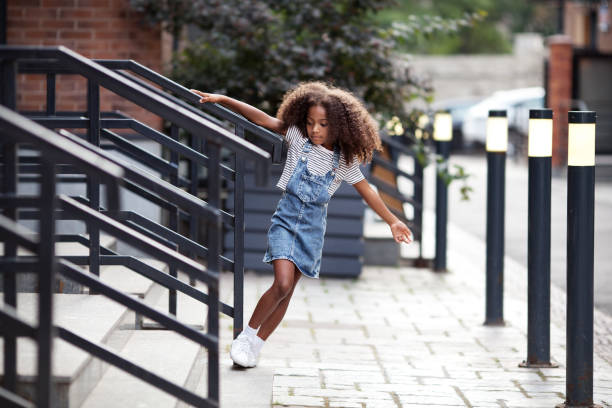ragazza afroamericana cammina lungo i gradini sulla strada della città. ritratto di bambino in gonna di denim e t-shirt all'aperto - black skirt foto e immagini stock