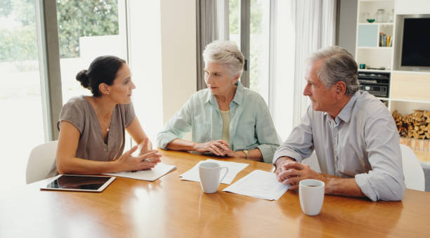 Senior, finance planning and financial advisor consulting elderly couple for paper will, estate policy and funeral budget. Retirement security, pension savings and investment growth for loan at home stock photo