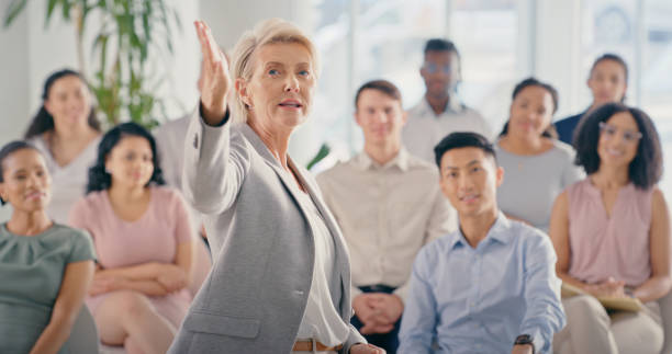 istock Boss, leader or ceo coaching, teaching and presentation in a work seminar or meeting in an office. Conference or training with woman company manager in a team leadership and management workshop 1423007139