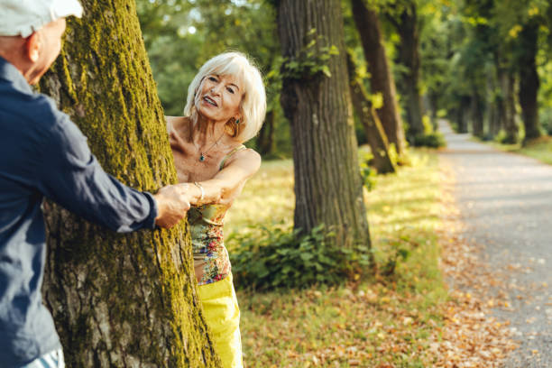 istock Senior couple standing around a tree holding hand at park 1423007143