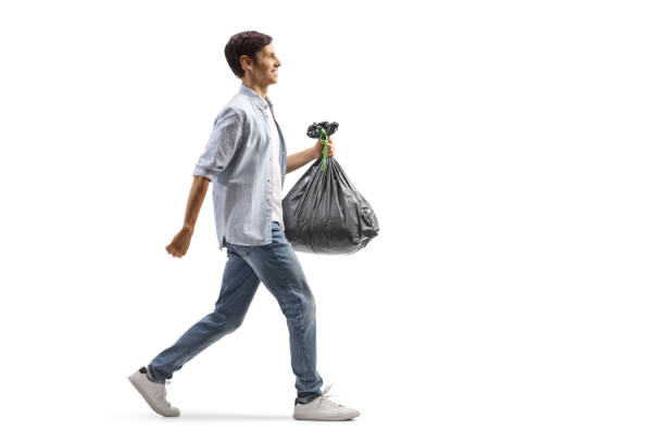 foto de perfil completo de un hombre casual caminando y llevando una bolsa de plástico - hit the sack fotografías e imágenes de stock