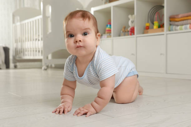 istock Cute baby crawling on floor at home 1423008544