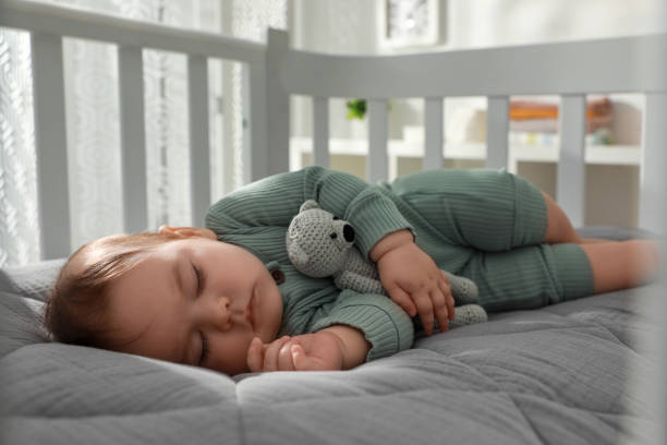 lindo bebé durmiendo en cuna en casa. hora de acostarse - cot fotografías e imágenes de stock