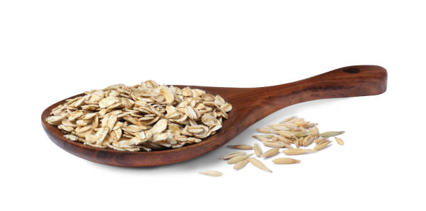 istock Raw oatmeal and wooden spoon on white background 1423009339