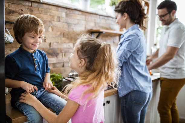 istock Happy little siblings talking in the kitchen. 1423009518