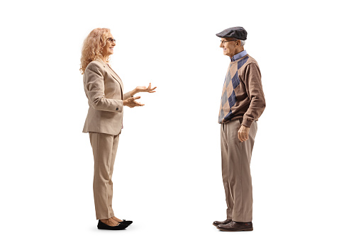 Full length profile shot of a mature woman talking to an elderly man isolated on white background