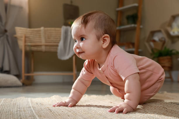 istock Cute baby crawling on floor at home. Space for text 1423009755
