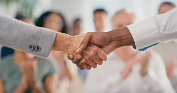 Handshake, thank you or B2b business deal with people shaking hands after success, welcome or hiring new corporate worker. Tradeshow audience celebrate a partnership, introduction or promotion stock photo
