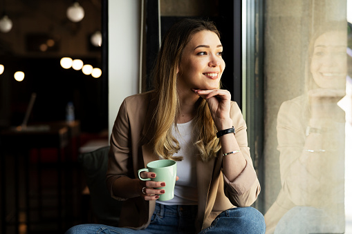 Businesswoman drinking coffee in the office. Beautiful woman enjoy in coffee break.