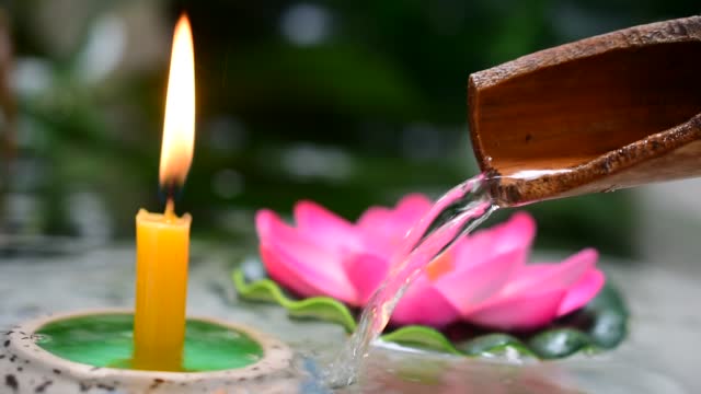 Flowing water trough lit lotus candles