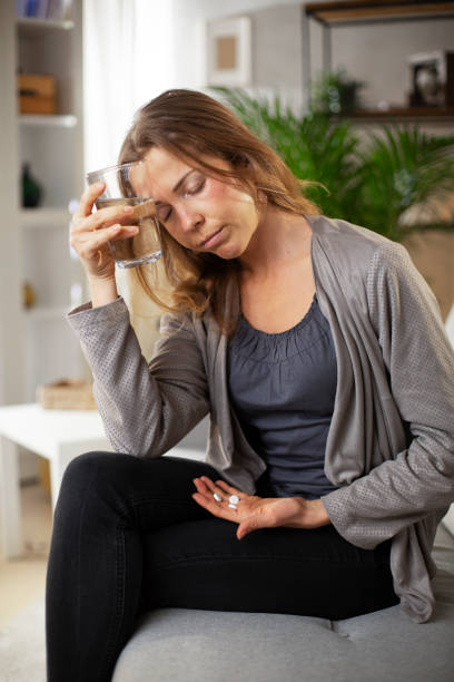 istock Woman sitting on sofa having fever. 1423010651