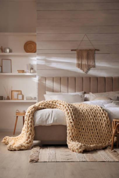 Soft chunky knit blanket on bed in stylish room interior
