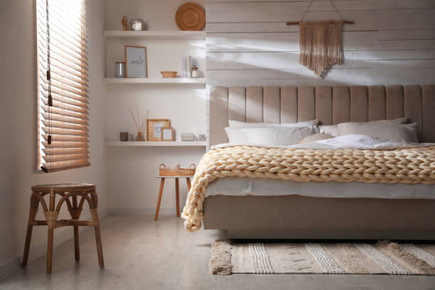 istock Soft chunky knit blanket on bed in stylish room interior 1423013775