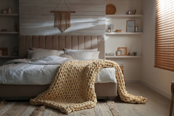 istock Soft chunky knit blanket on bed in stylish room 1423013871