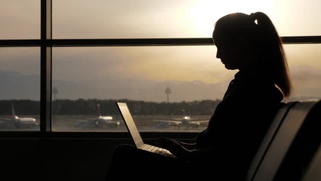 Mujer freelancer utiliza el tiempo de espera de su vuelo, para completar tareas urgentes photo