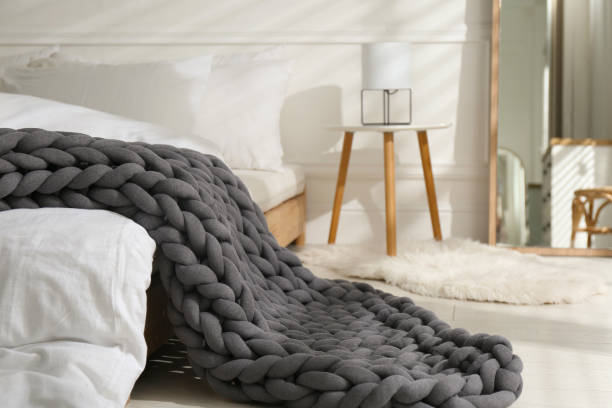 istock Soft chunky knit blanket on bed in room 1423014287