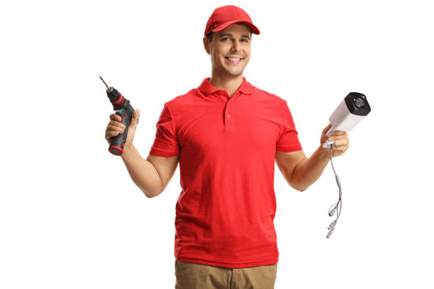 Worker holding a surveillance camera and a drill machine Worker holding a surveillance camera and a drill machine isolated on white background holding drill stock pictures, royalty-free photos & images