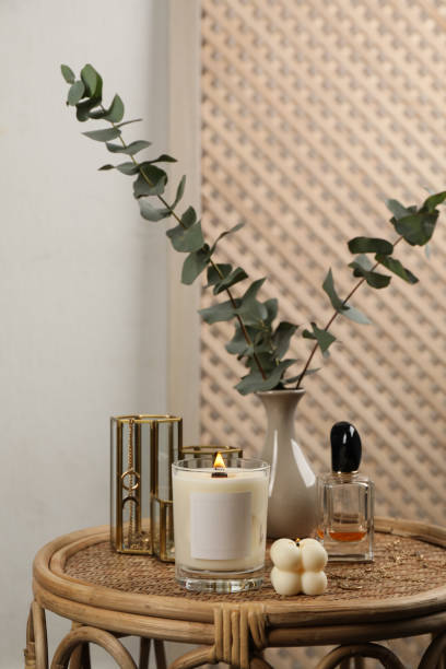 istock Burning soy candle, perfume and stylish accessories on wicker table indoors 1423016161