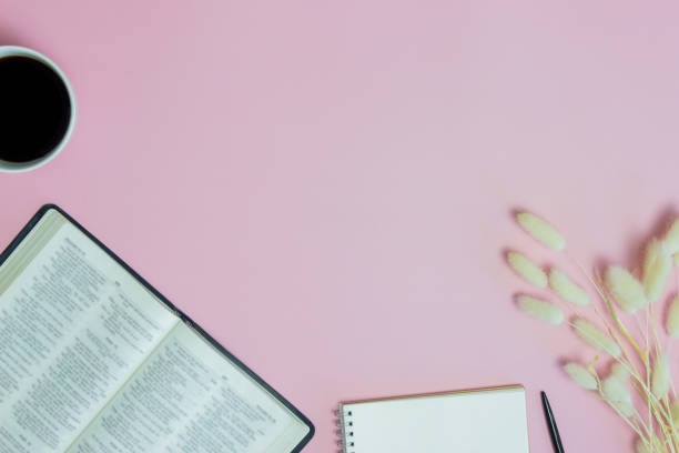 istock Holy Bible with coffee, notebook and white flowers over the pink background. 1423016633