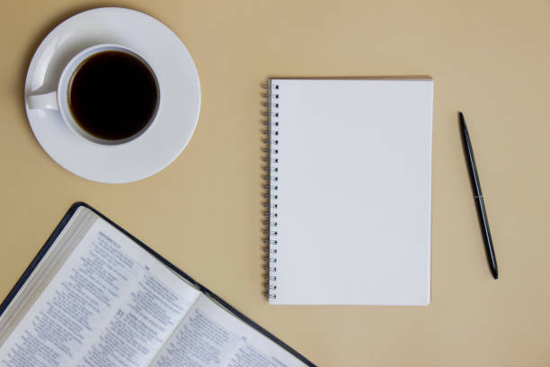 istock Opened Bible with black coffee, notebook and pen over the brown background. 1423016679