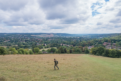 Hiking man walking in the field, Amazing view of Goring and Streatley, village town near Reading, England.