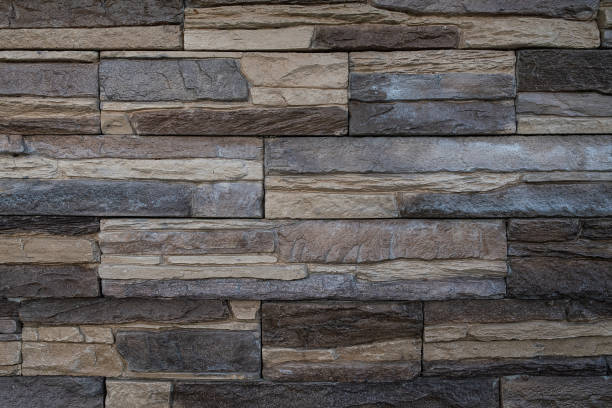 Artificial stone brick wall with the look of pressed together flat stones Artificial stone imitation brick wall with the look of pressed together flat stonesof different colour to create an interesting texture. architectural exterior marble stone wall texture stock pictures, royalty-free photos & images